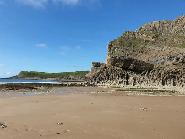 Honeycombed limestone cliffs above the sand at Fall Bay