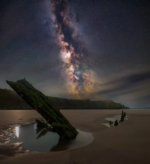 The ribs of the Helvetia wreck on Rhosili beach at night beneath the Milky Way