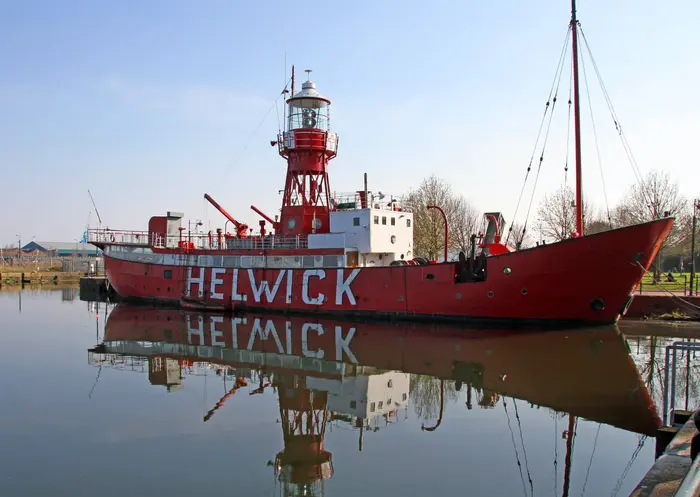 The Helwick lightvessel in earlier, better-kept condition, moored and reflected in calm water