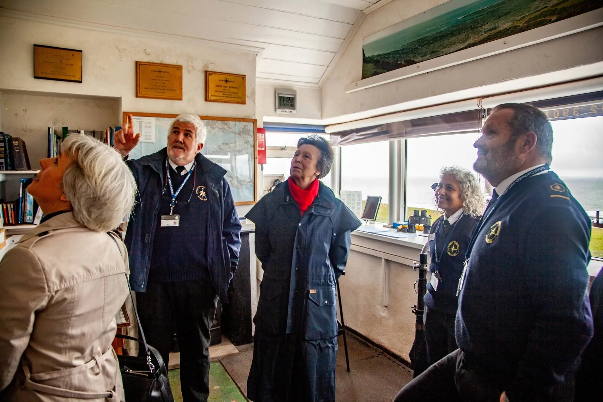 HRH The Princess Royal touring the watch room at NCI Worms Head Lookout Station, with Station Manager Andy Bowen pointing out the world visitors map