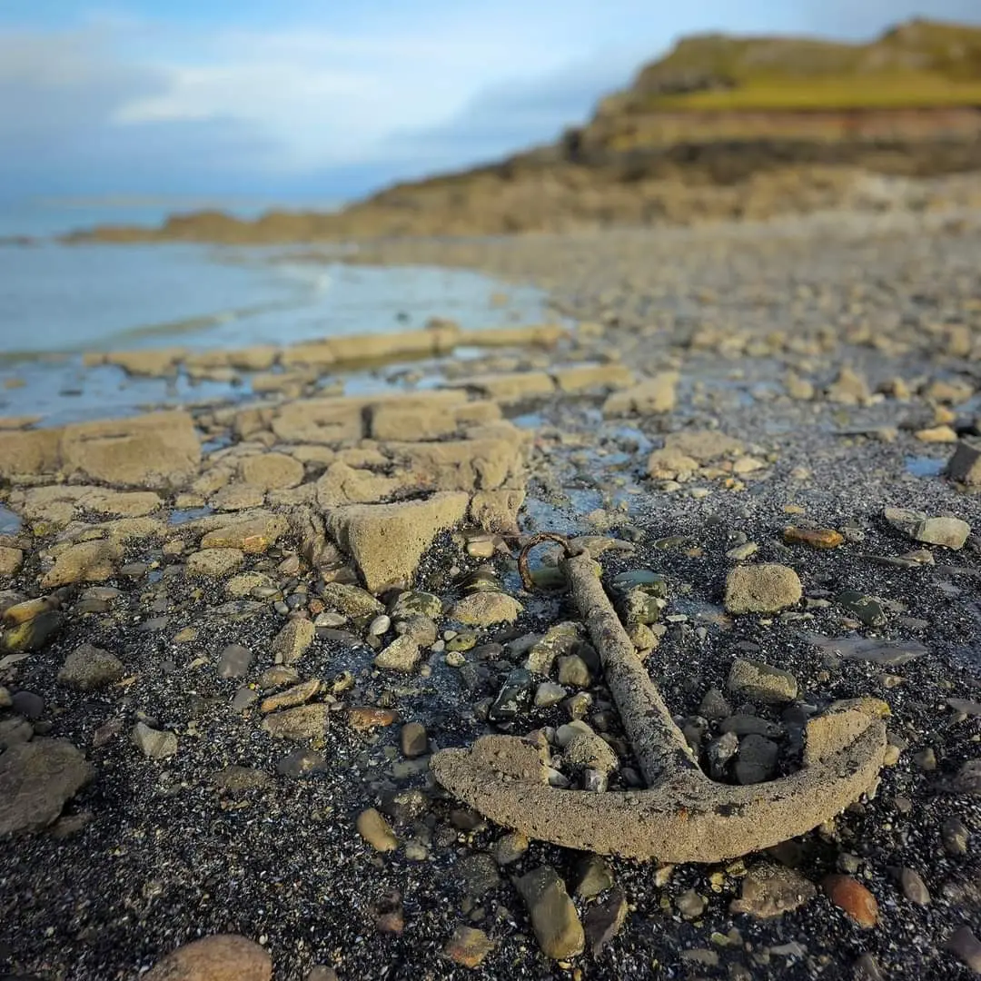 The rusted anchor from the wrecked collier Samuel, embedded in the rocks of the Worms Head causeway