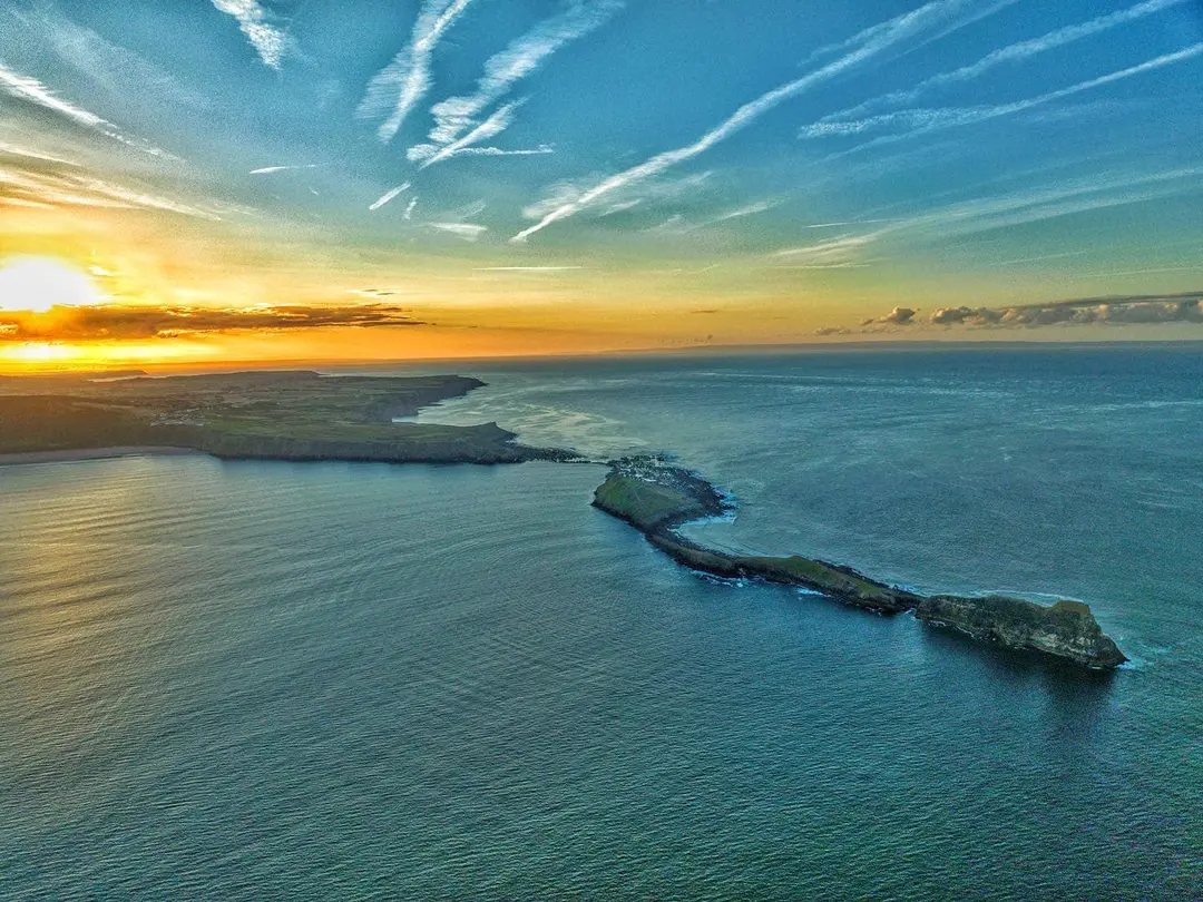 Aerial view of Worms Head at sunset, from the causeway and Inner Head out to the Outer Head, with the Gower coast behind